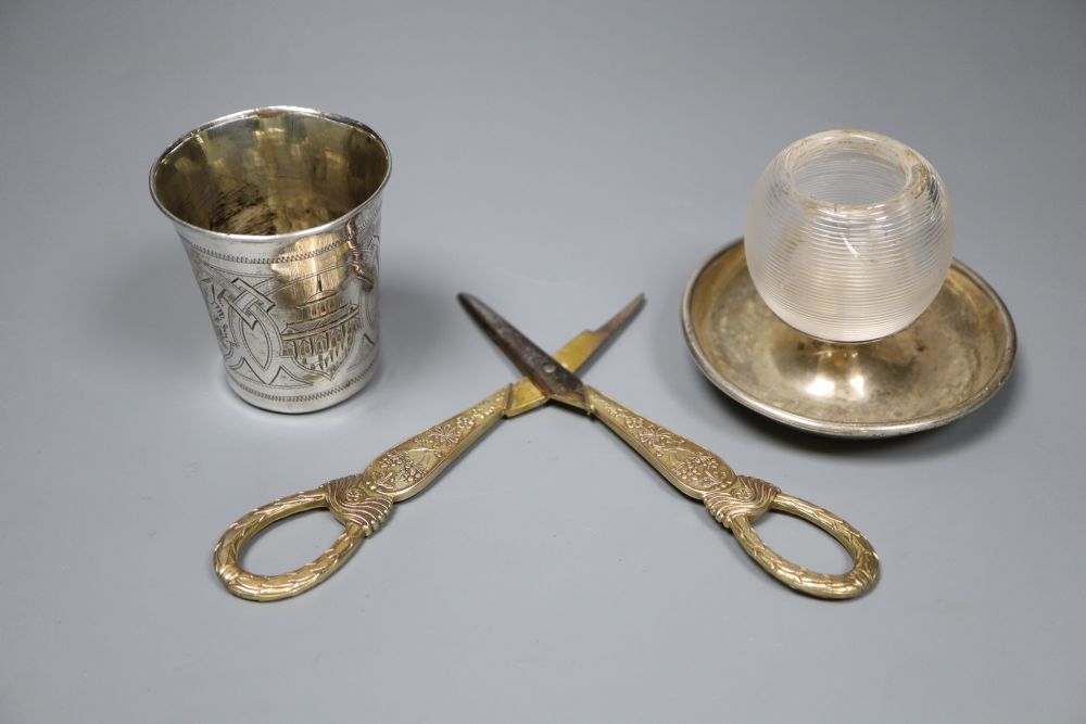 A late 19th century Russian engraved 84 zolotnik beaker, 63mm, a silver mounted glass match strike(a.f.) and a pr of scissors.